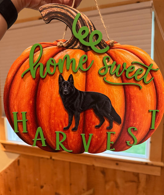 Layered orange pumpkin wood fall sign featuring a black German Shepherd, green lettering, and a hanging cord.